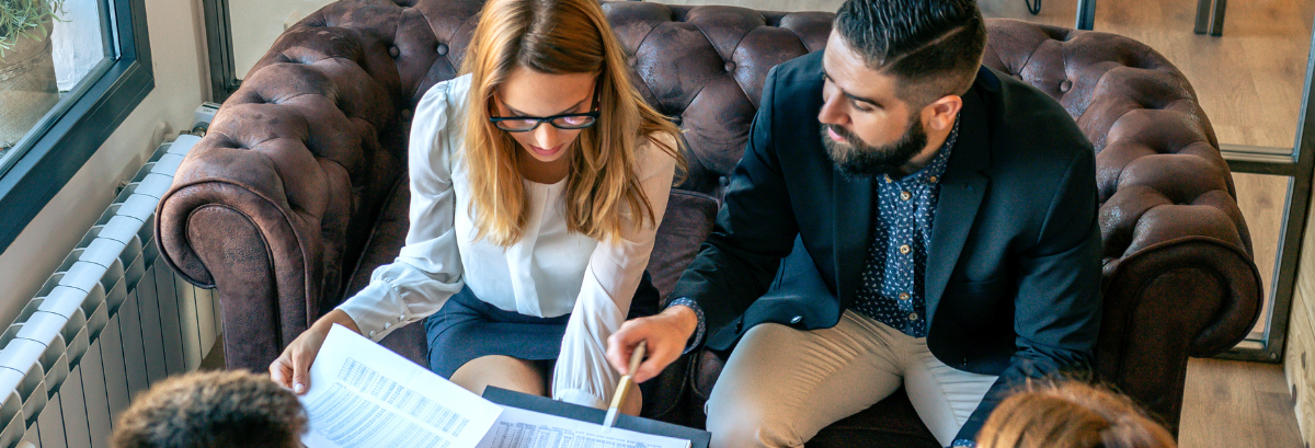two people sitting, reading over financial documents