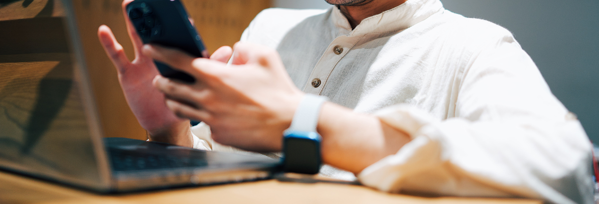 person at their desk with computer and phone