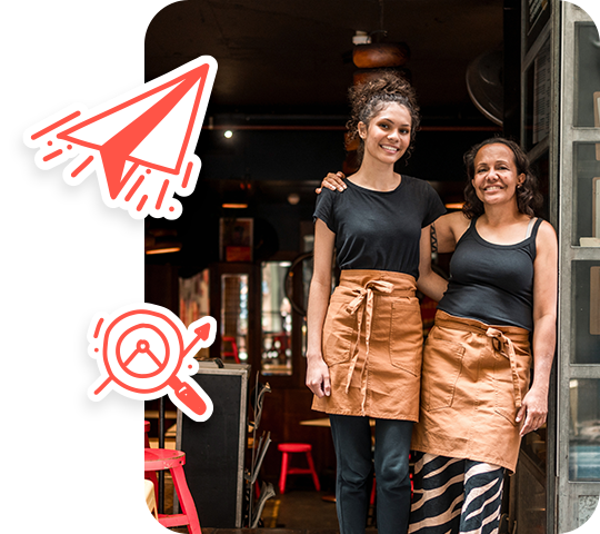 Two cafe workers at the door of their cafe